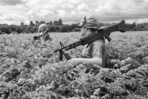 Two Vietnam reenactors walking in the long grass outside the site's fence line.