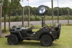 A World War 2 US Army Jeep with a searchlight mounted on top.