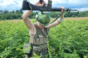 Vietnam reenactor walking in the long grass outside the site's fence line.
